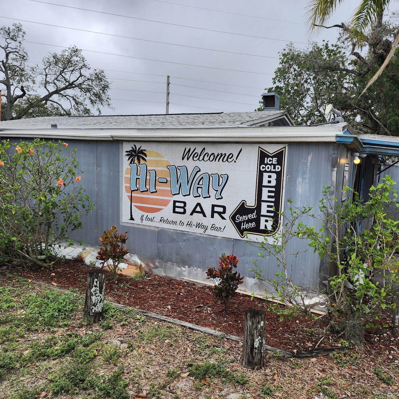 The hand-painted Hi-Way Bar sunset mural and Ice Cold Beer sign on the side of the building